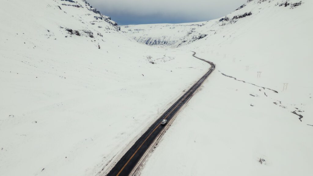 Patagonia argentina Se ve un valle nevado con la ruta que conduce a la ciudad de Caviehue con una camioneta 4x4 recorriendola