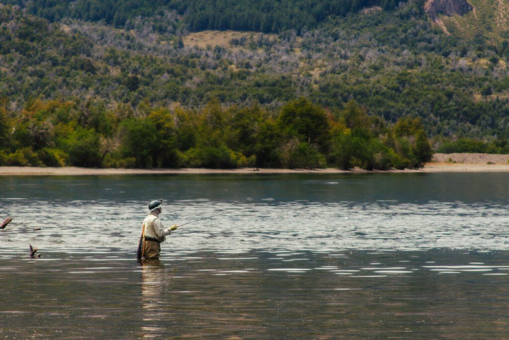 pescador en lago meliquina tirando si caña de pescar, pesca con mosca